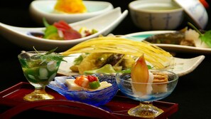 Variedad de platos, incluyendo un vaso de té helado con menta, un bol de mariscos y un plato con fideos y vegetales.