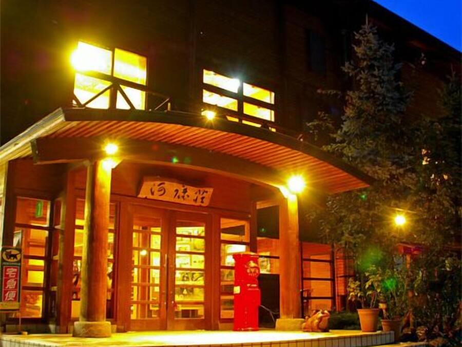 A building with a wooden facade, large windows, and a sign above the entrance.