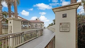 Una passerella in legno che conduce a un edificio con un cartello che recita 'Solo Soci e Residenti'.