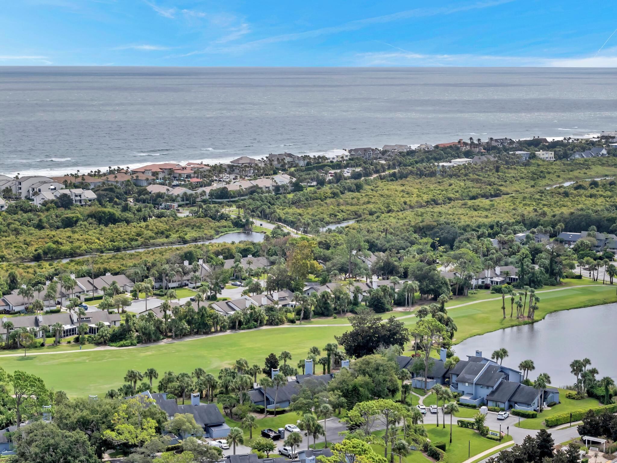Un quartier résidentiel situé sur la côte, avec des maisons, un terrain de golf et un lac.