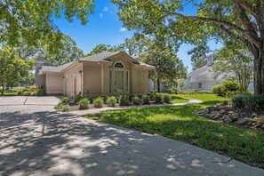 A single-story house with a front entrance, a covered porch, and a well-maintained lawn.