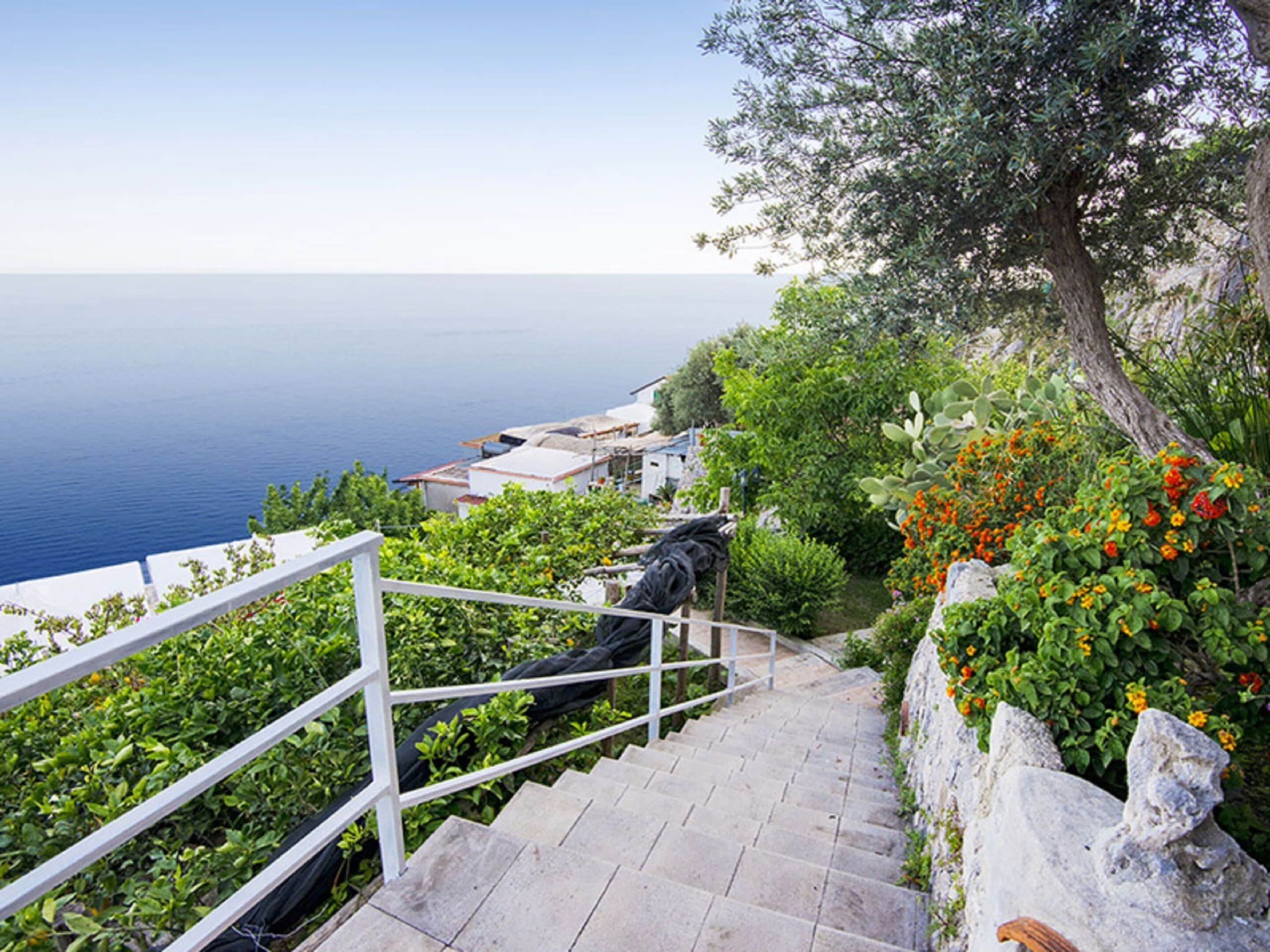 A staircase leading down to a coastal area with a view of the sea.