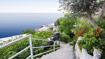A staircase leading down to a coastal area with a view of the sea.