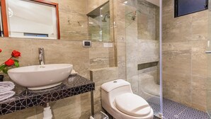 Une salle de bain moderne avec un grand lavabo blanc, des toilettes et une douche à parois de verre.