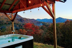 A hot tub under a wooden pergola with a mountainous landscape view. - Majestic View | Near Town/Train | FirePit | HotTub (Bryson City)