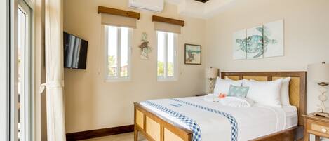 Un dormitorio con cama de madera, ventilador de techo y una ventana grande con vistas al exterior.
