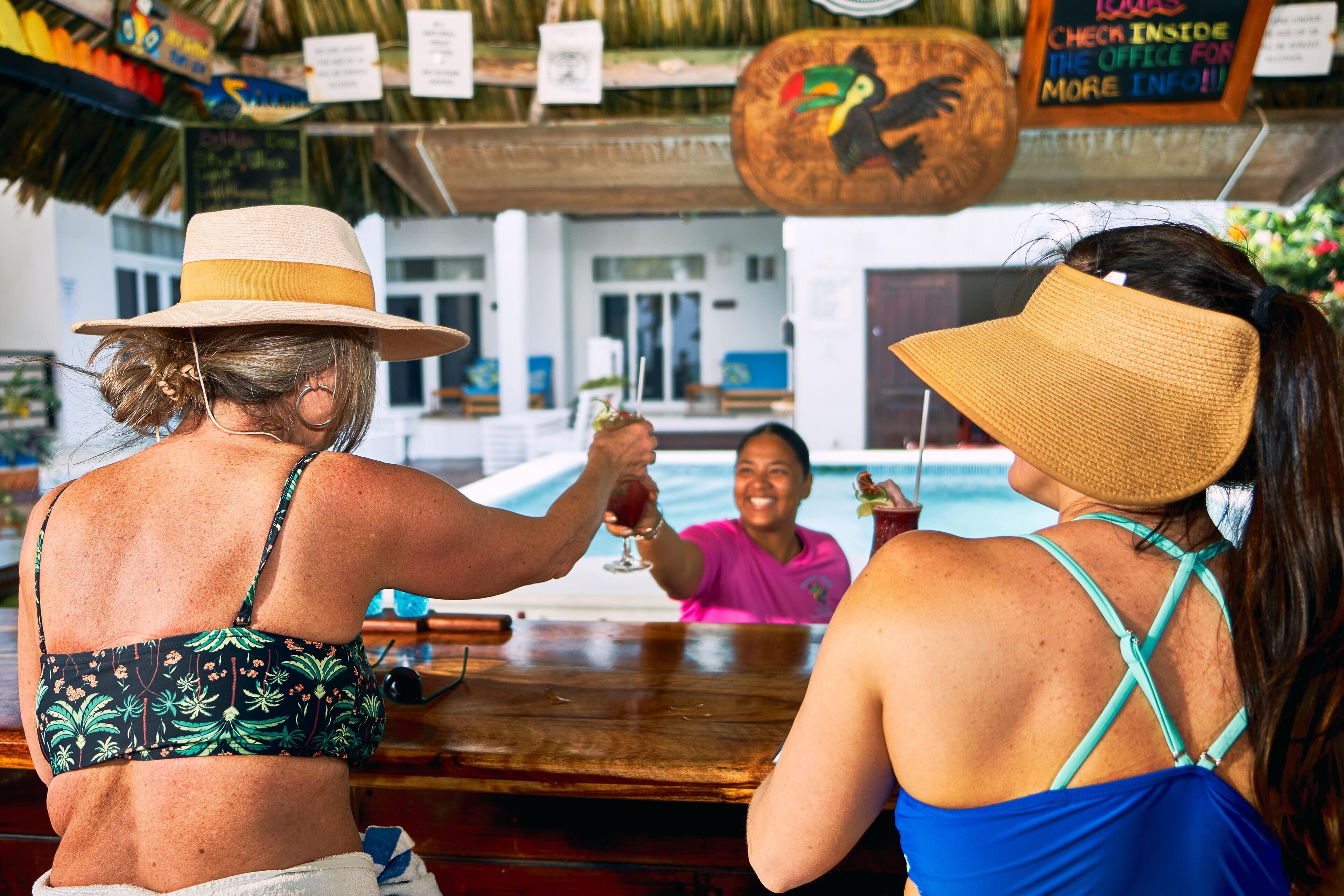 Two people at a bar with a pool in the background.