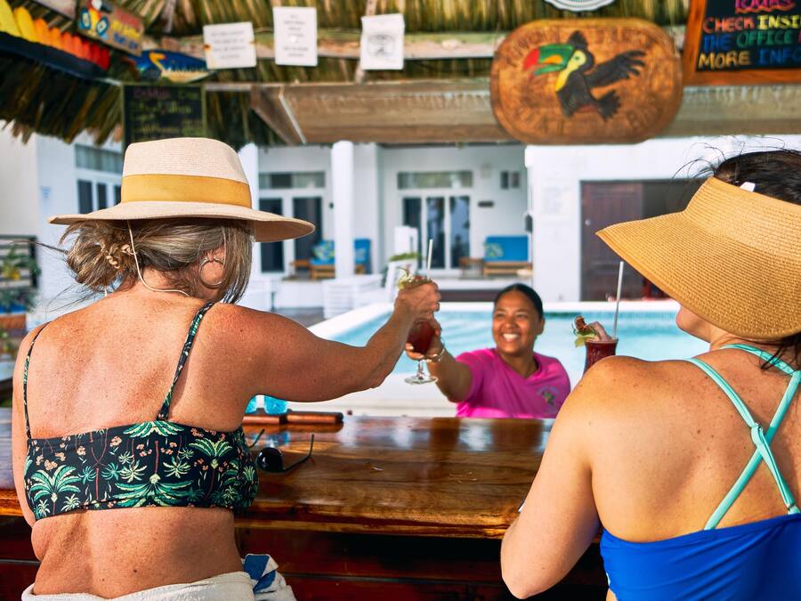 Two people at a bar with a pool in the background.