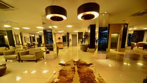 Un hall d’entrée spacieux, agrémenté d’un grand tapis en fourrure, d’un éclairage moderne et de coins salon.