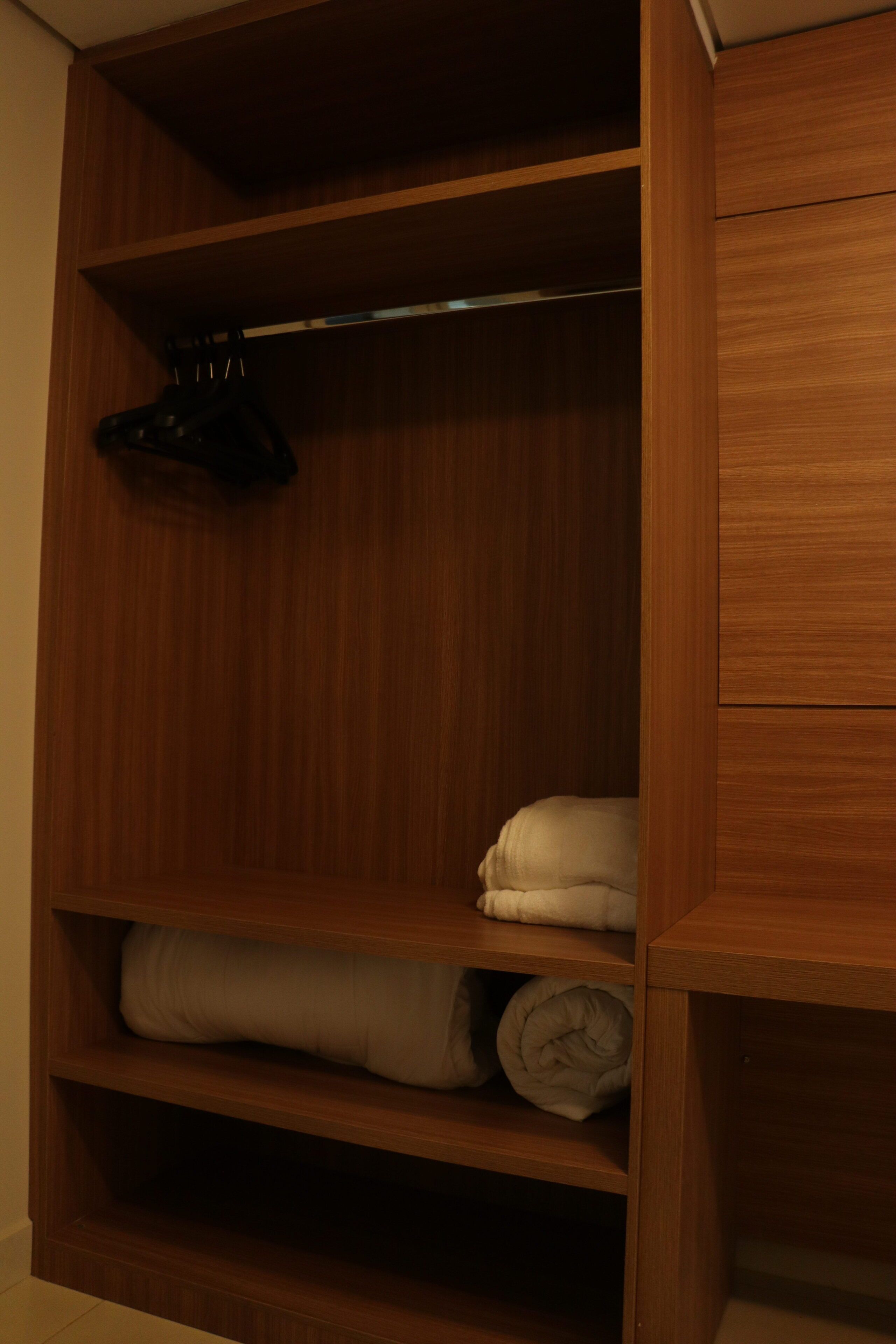 Un armario de madera con repisas y espacio para colgar.