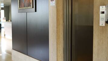 An elevator with a sign indicating no smoking.