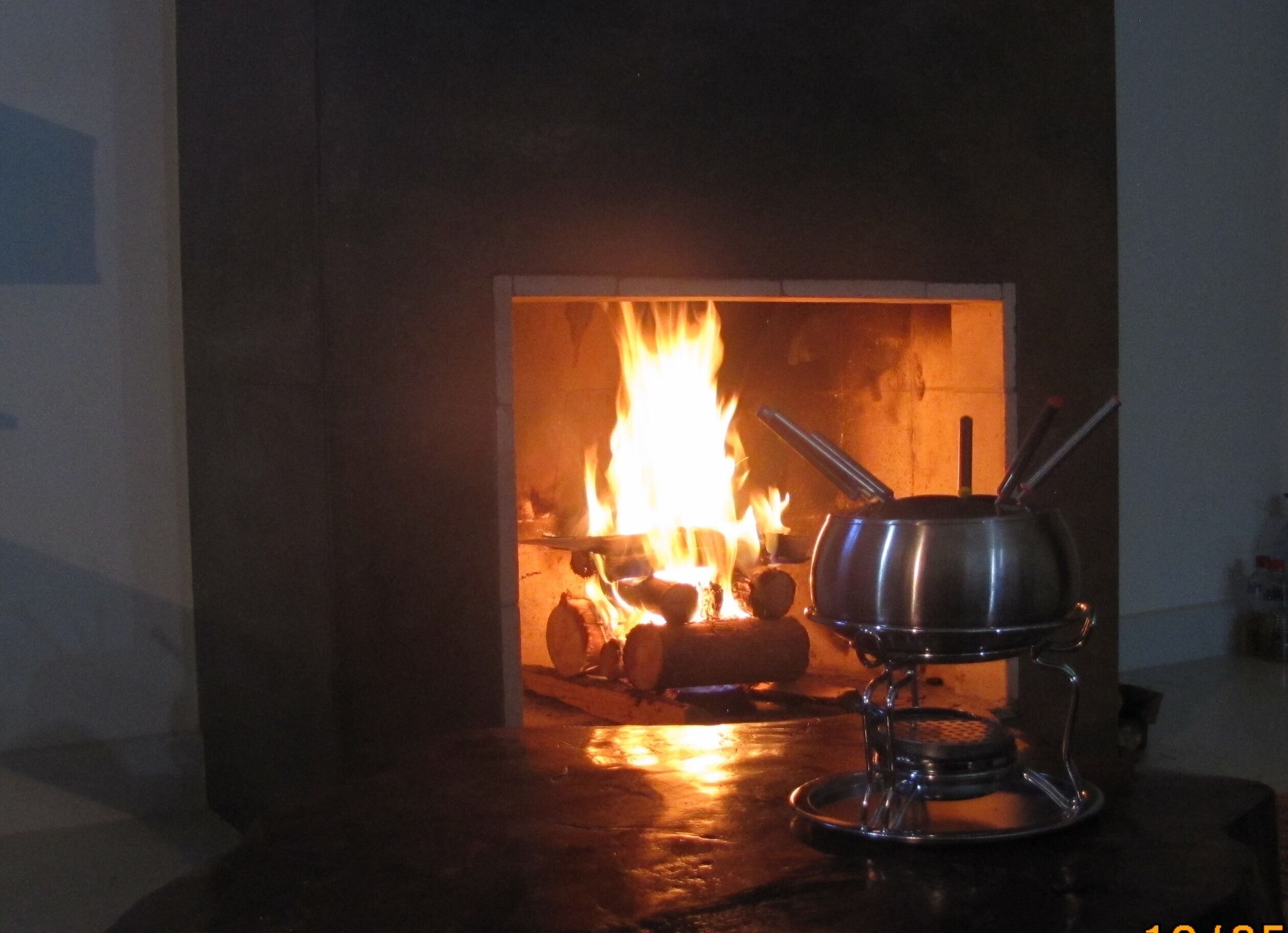 A kitchen with a stove and a pot on a portable stove.
