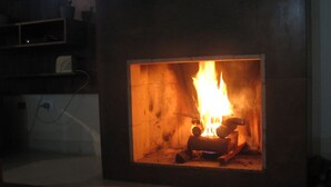 Une cheminée dans laquelle on peut voir le feu brûler.