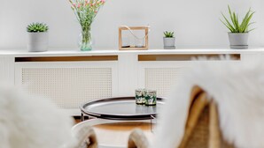 Una stanza con un'ampia finestra, una lampada a sospensione e un tavolino con oggetti decorativi.