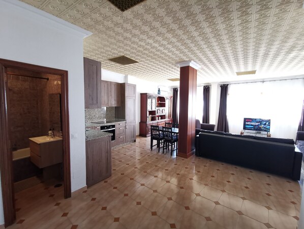 A spacious living area with a kitchen, dining area, and a seating area with a TV. - SPACIOUS APARTMENT NEXT TO SEA. MALAGA, EL PALO. (Málaga)