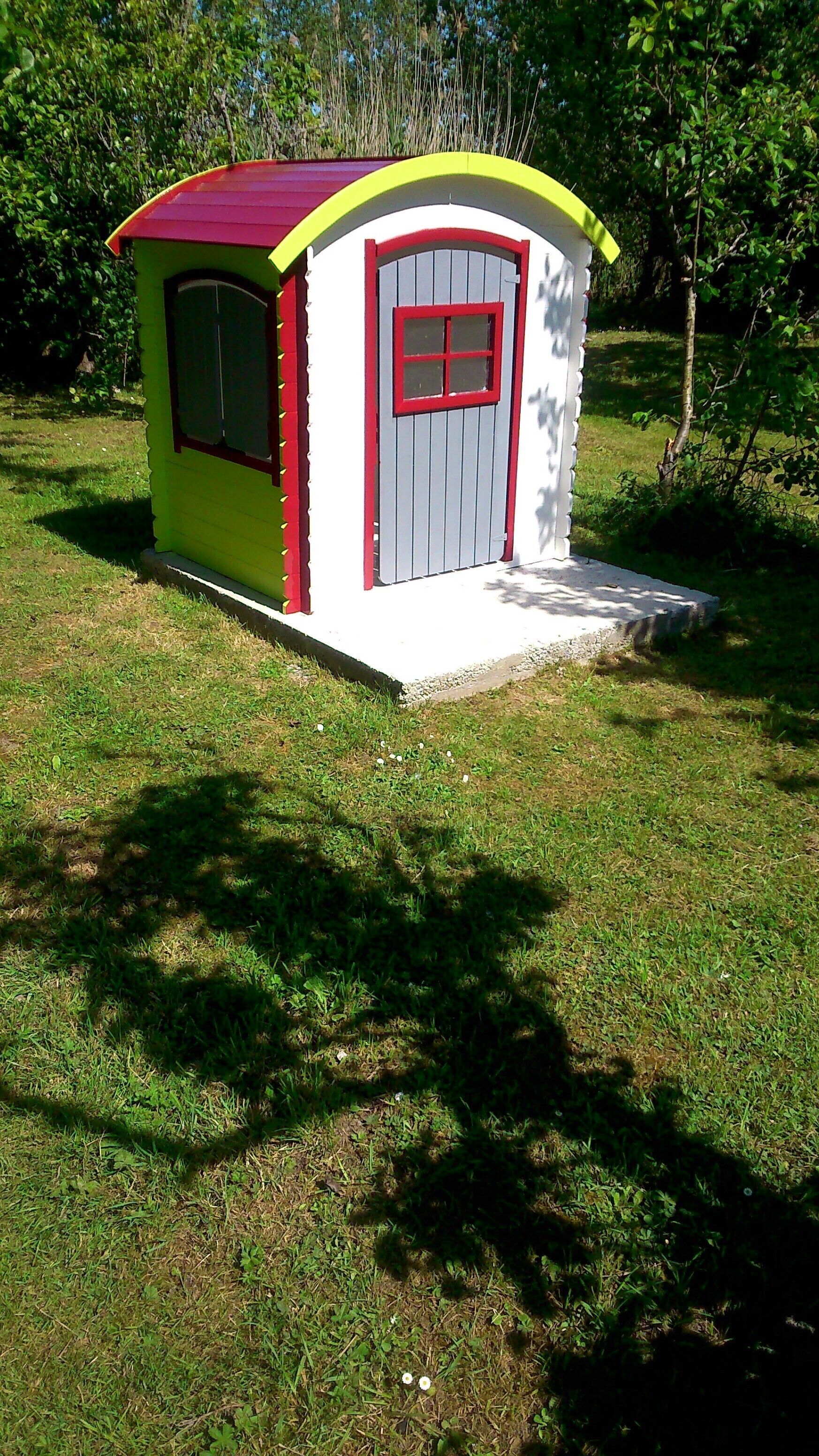 Una piccola costruzione a un piano, con tetto rosso e pareti bianche, dotata di una porta e una finestra.