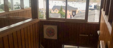 Un interior de madera con vista al frente marítimo y montañas.