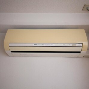 A white air conditioning unit mounted on a wall. - Kisyaba Hotel (Kagoshima)