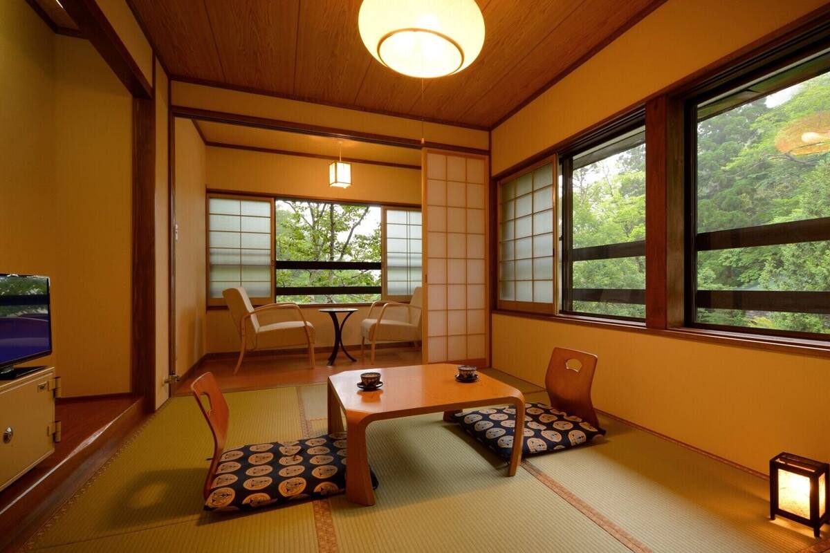 A traditional Japanese room with tatami flooring, a low table, and sliding shoji doors.