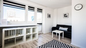 A modern living room with a black sofa, a white coffee table, and a black and white rug. - Elegant Apartment Panoramic (Warsaw)