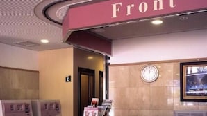 A reception area with a 'Front' sign, a clock, and a framed picture on the wall.