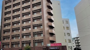 A multi-story hotel building with a red sign indicating 'HOTEL' and 'PARKING IN' on the ground floor.