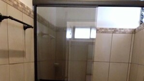 A bathroom with a glass-enclosed shower, a toilet, and a sink. - Cabinas Ledezma (Mogote de Bagaces)