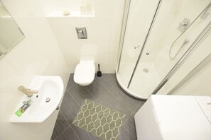 A modern bathroom with a sink, toilet, and shower. - Elegant Apartment Old Town V (Warsaw)