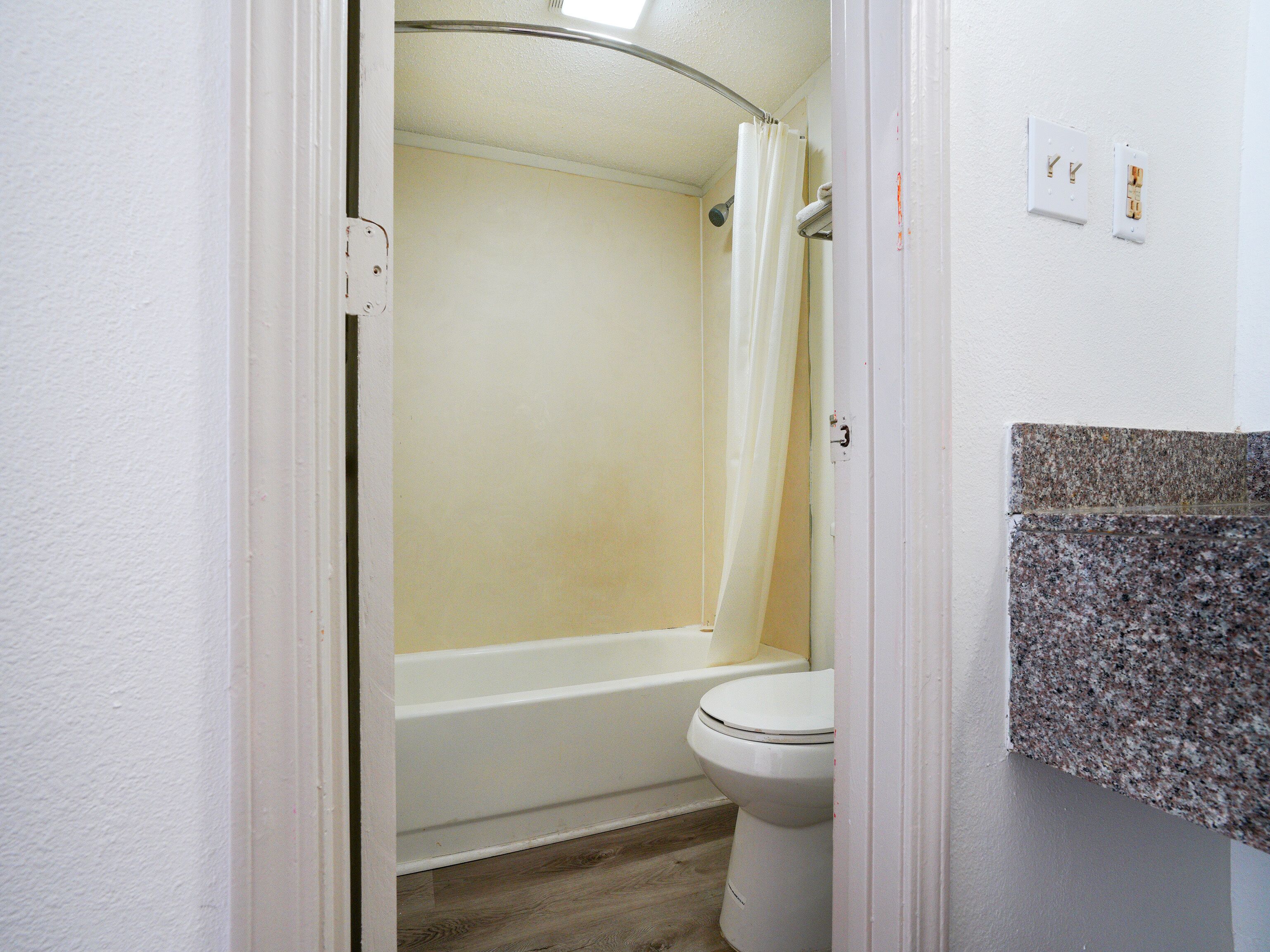 Un baño con una bañera blanca, un inodoro y una cortina de ducha.