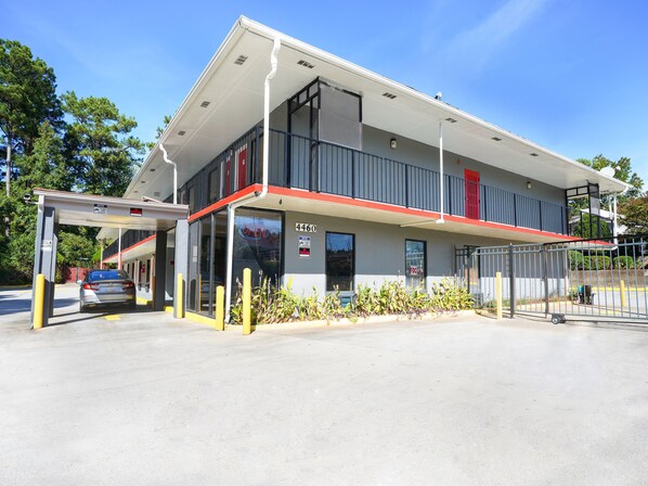 A two-story building with a covered entrance, a visible number '4460', and a gated parking area.
