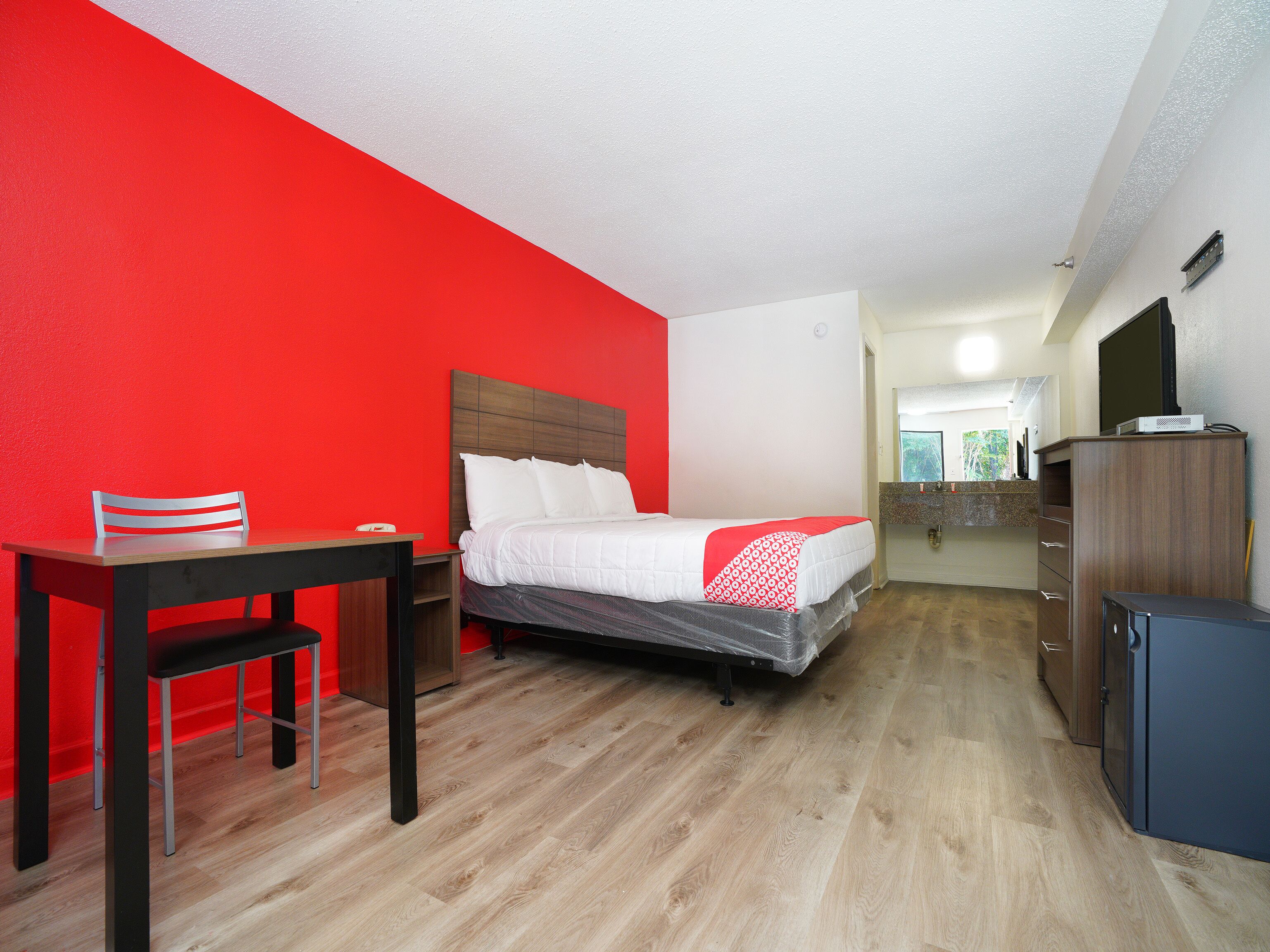 Una habitación de hotel con una cama, un escritorio y una silla.