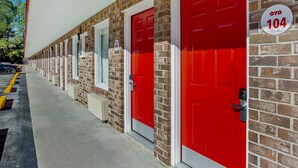 A row of red doors with a sign indicating room number 104. - OYO Hotel Ridgeland East (Ridgeland)