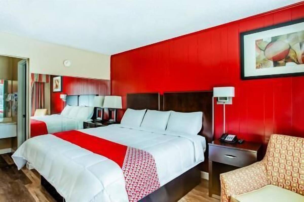 A hotel room with a large bed, bedside tables, a desk, and a chair.