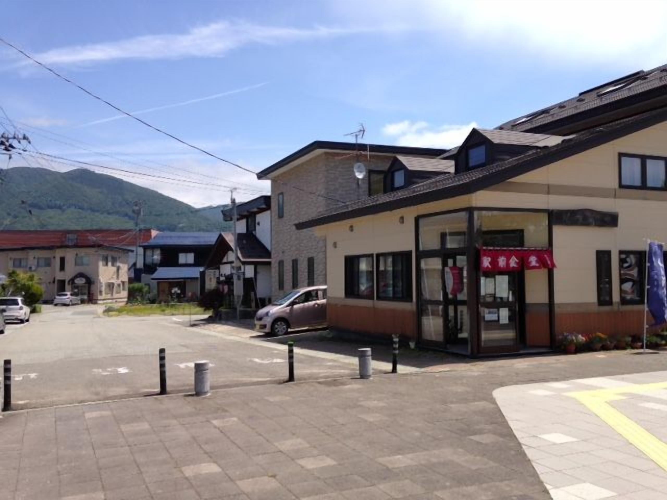 A building with a storefront and a parking area in front.