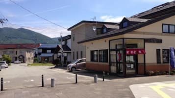 A building with a storefront and a parking area in front.