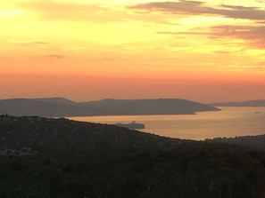 Experience the serene tranquility of a coastal landscape with a calm water body and rolling hills.