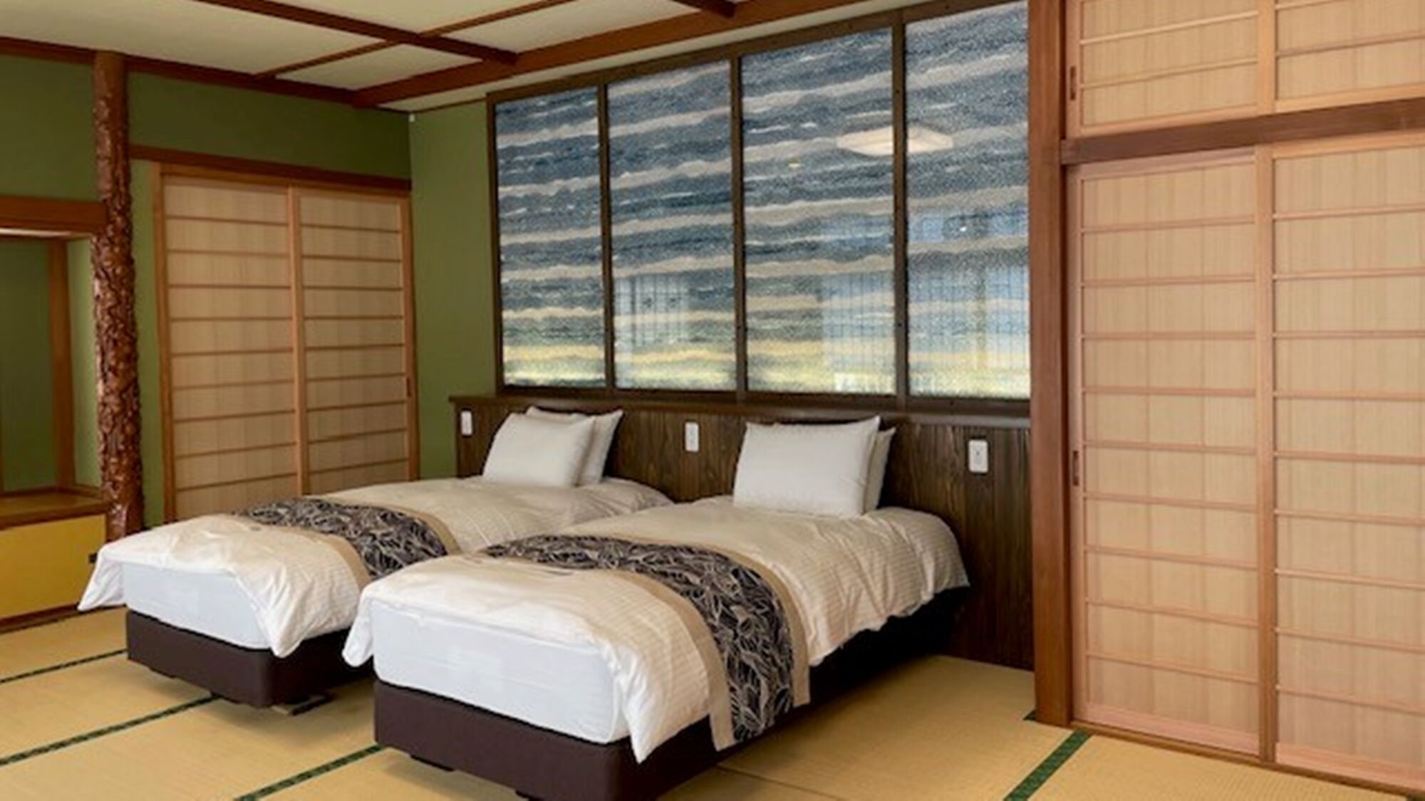 A traditional Japanese-style room with tatami flooring, a shoji screen wall, and a sliding door.