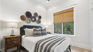 A bedroom with a bed, bedside tables, a window with blinds, and wall decor. - Carriage House | 30 Sec Walk to Beach | Pool Access | Across Eastern Green (Rosemary Beach)