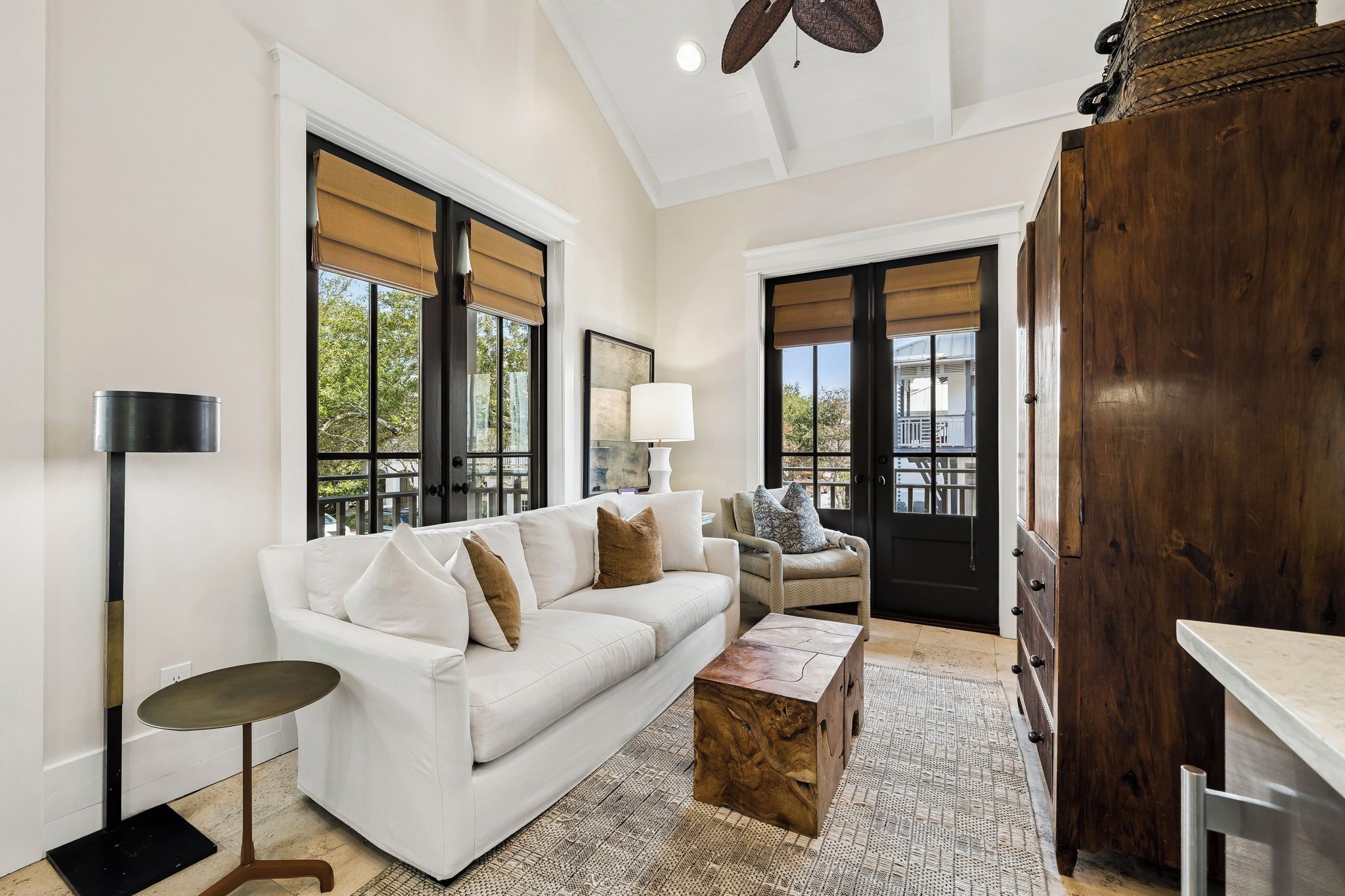 A modern living room with a white sofa, a wooden coffee table, and a floor lamp.