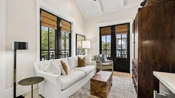 A modern living room with a white sofa, a wooden coffee table, and a floor lamp.