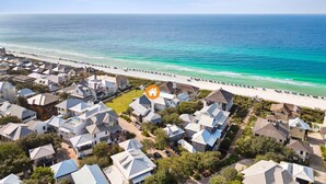 Un quartier résidentiel situé sur la côte, avec des maisons, une plage et une vue dégagée sur l’océan.