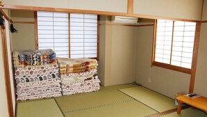Une pièce de style japonais traditionnel, avec un sol recouvert de tatamis, un lit bas en bois et une petite table.