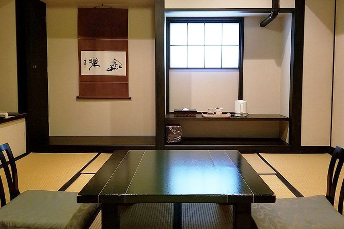 Een traditionele Japanse kamer met tatami vloerbedekking, een lage tafel en een schuifdeur.