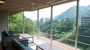 A modern room with large windows, a wooden deck, and a view of a mountainous landscape. - Kinu No Keikoku Hekiryu (Nikko)