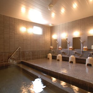 Un bagno moderno con un ampio specchio, diversi lavandini e una zona piscina centrale.