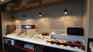 A buffet setup with various food items, a microwave, and a coffee machine. - Ab Hotel Okazaki (Okazaki)