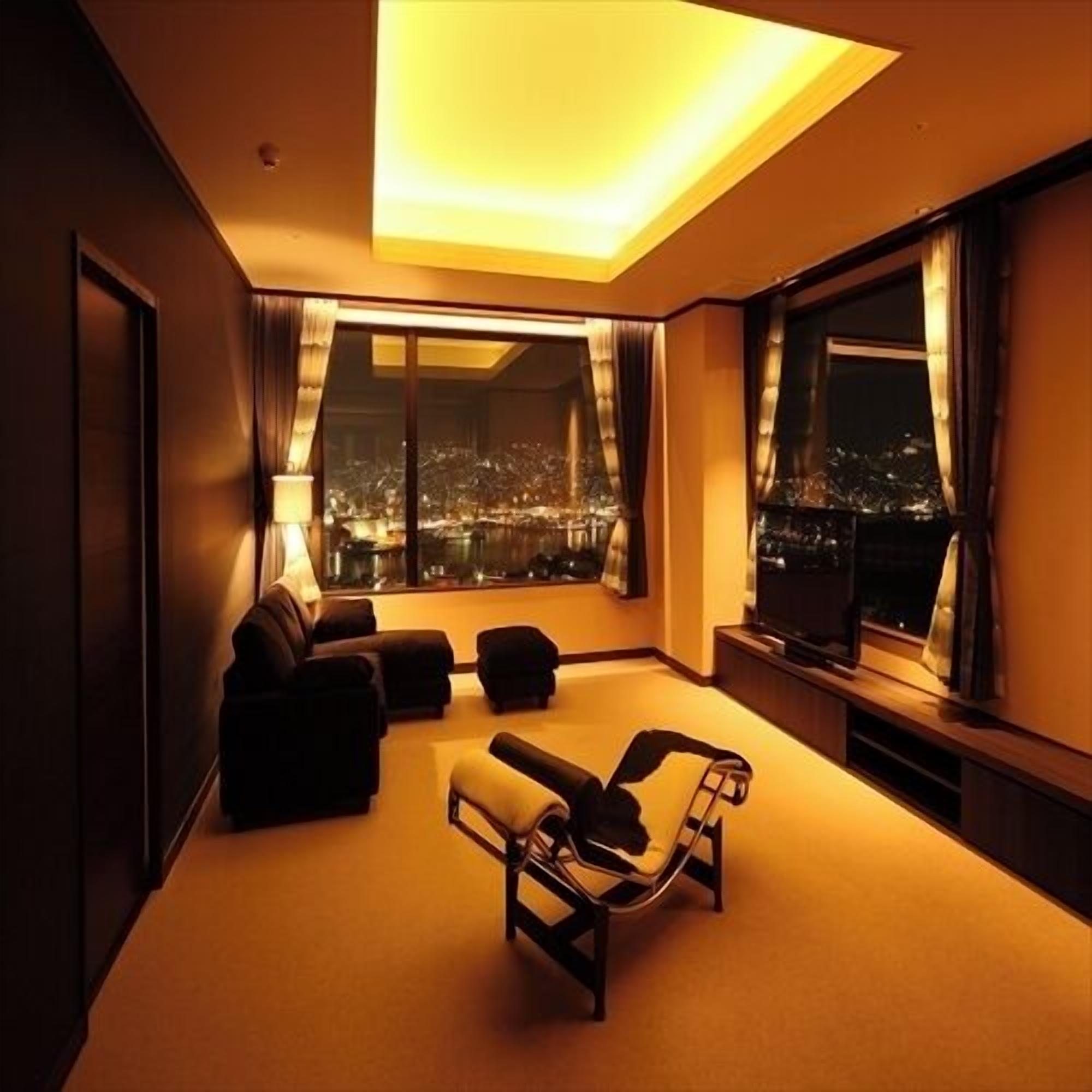 Una sala de estar moderna con un sofá, sillones y un televisor.