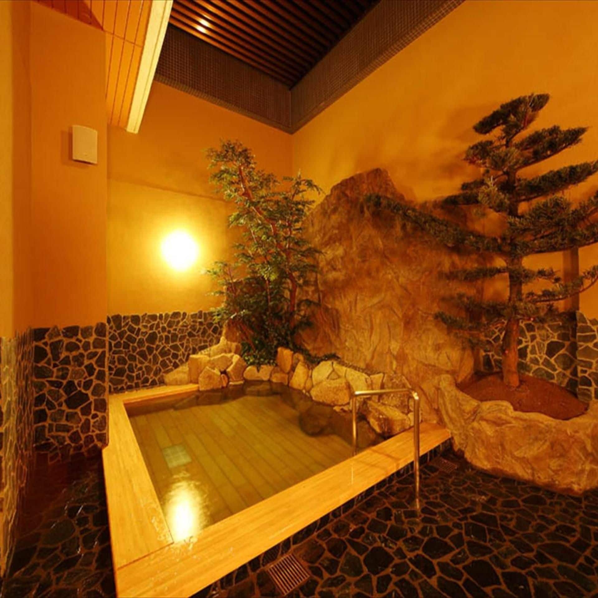 A spa room with a hot tub, stone walls, and a rock formation.