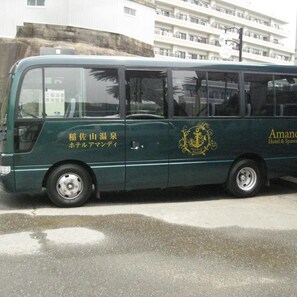 A green bus with 'Amano Hotel & Spares' branding and a logo on the side.