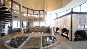 Un vaste atrium doté d’un élément aquatique central, de plusieurs niveaux avec balcons et d’un escalier.